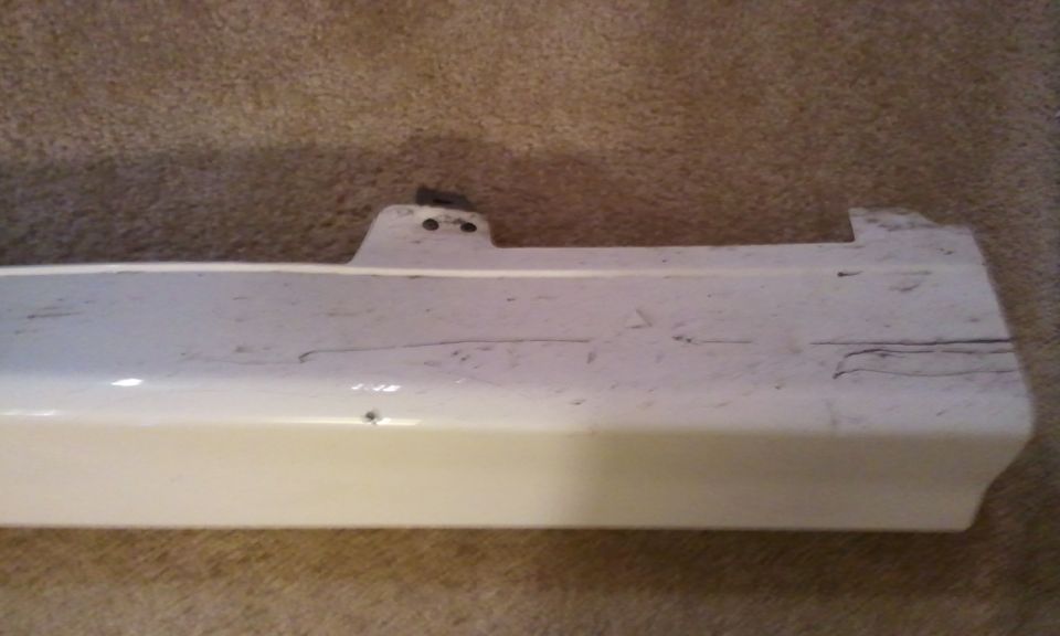 White car bumper part with scuff marks