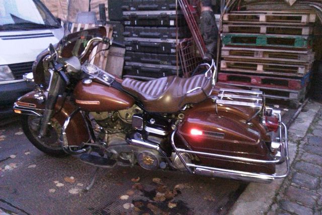 Brown motorcycle parked outdoors, side view