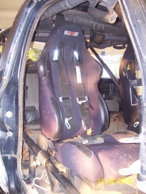 1978 Ford Bronco - Custom interior with racing seats and a roll cage, a Ralliart logo on the driver's seat.