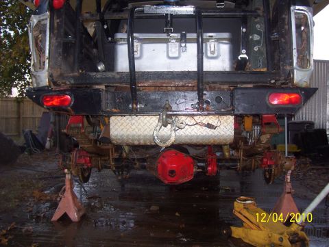 1978 Ford Bronco - The rear of a vehicle is shown on jack stands, with aftermarket parts visible on the suspension and drivetrain.