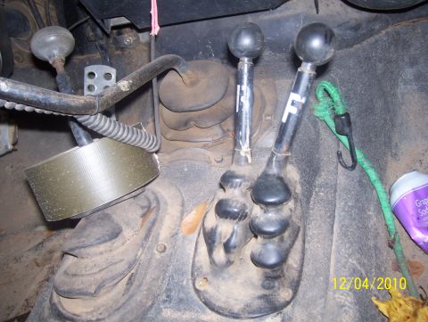 1978 Ford Bronco - Close-up of the interior of a vehicle, showing two gear shifters and other components.