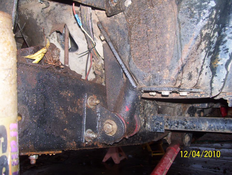 Close-up of rusty vehicle frame and suspension with visible wiring