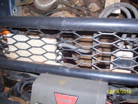 1978 Ford Bronco - Close-up view of vehicle engine compartment components and a winch, partially obscured by a protective grille.