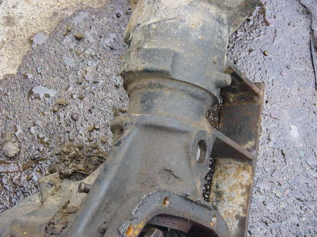 Close-up of a greasy differential housing with a Supermotors logo in the corner