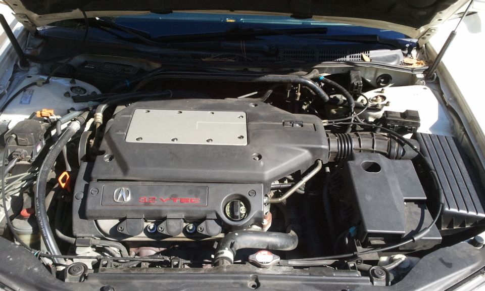 Engine bay with V6 VTEC engine cover and Acura logo. Air intake system visible