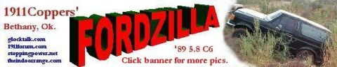 1995 Ford Bronco - A black Ford Bronco is partially submerged in tall grass and dirt, with the text 'FORDZILLA' prominently displayed.