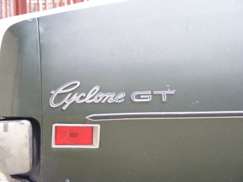 1971 Mercury Cyclone - The rear of a green vehicle displays a 'Cyclone GT' emblem and a red taillight assembly.