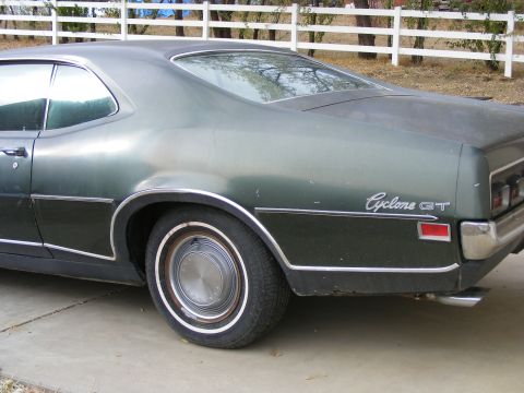 1971 Mercury Cyclone - The rear quarter panel of a 1971 Mercury Cyclone GT is visible, with its distinctive badging and chrome trim.