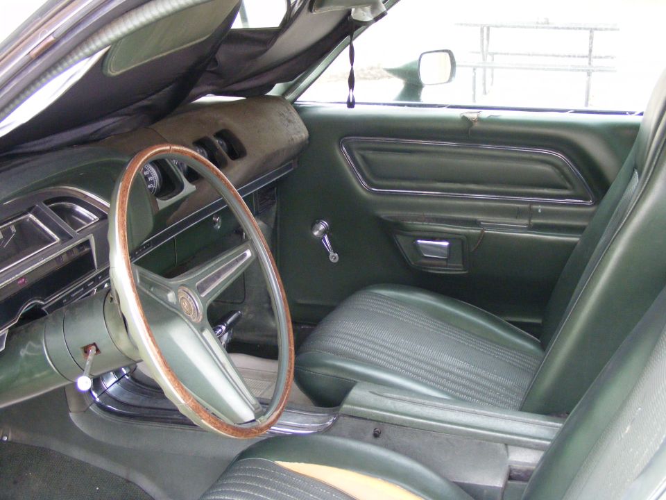1971 Mercury Cyclone interior with green seats and wood-rimmed steering wheel