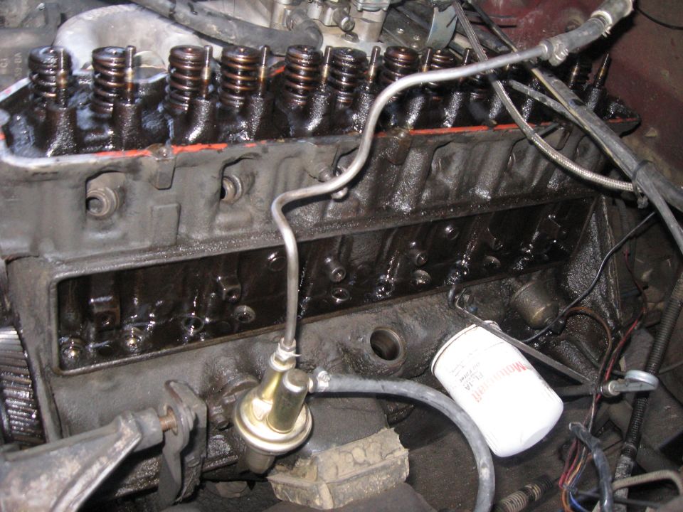 In-vehicle V8 with intake manifold removed, exposed lifter valley, fuel pump and oil filter