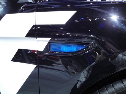 1993 Ford Taurus - Close-up of a black car's side panel a white graphic and a blue light.