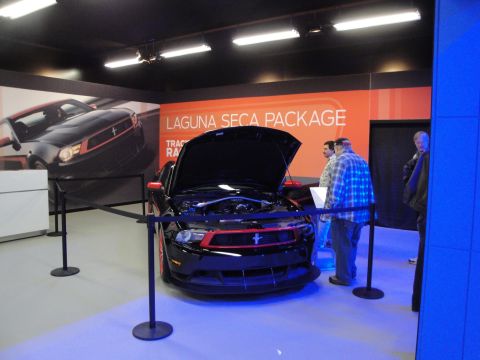 1993 Ford Taurus - A black Ford Mustang with red trim is displayed with its hood open, the Laguna Seca Package.