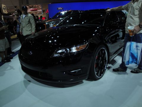1993 Ford Taurus - Black Ford sedan on display at an auto show.