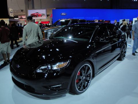 1993 Ford Taurus - Black sedan on display at the LA Auto Show, with Ford Mustang Challenge branding in the background.