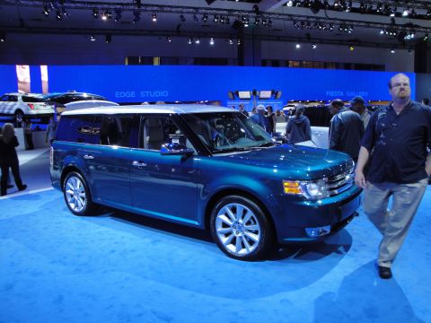 1993 Ford Taurus - A blue SUV with a silver roof is displayed on a blue carpet at an auto show, with text reading 'EDGE STUDIO' in the background.