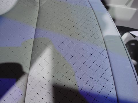 1993 Ford Taurus - Close-up of a perforated white leather seat with a diamond pattern, likely from a car interior.