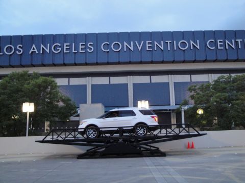 1993 Ford Taurus - White SUV displayed on a platform outside the Los Angeles Convention Center.