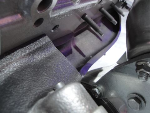 1993 Ford Taurus - Detail shot of engine parts, including metal castings and fasteners, with a hint of purple paint.