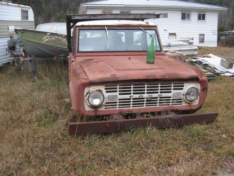 1981 Ford Bronco - This weathered Ford Bronco sits in a grassy yard next to a trailer with a boat.