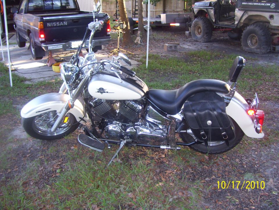 White and chrome motorcycle with black saddlebags, parked outdoors