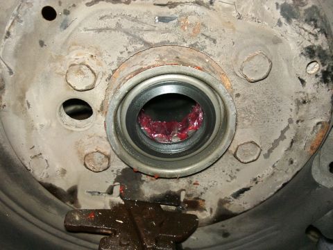 1998 Ford Crown Victoria - Wheel bearing assembly, likely from a Ford Crown Victoria, packed with red grease during maintenance.