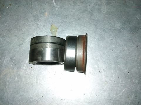 1998 Ford Crown Victoria - Two axle bearings are shown on a metal surface, likely for a vehicle's axle work.