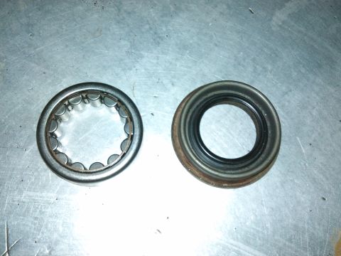 1998 Ford Crown Victoria - A roller bearing and a seal are shown on a metallic surface, likely automotive parts.