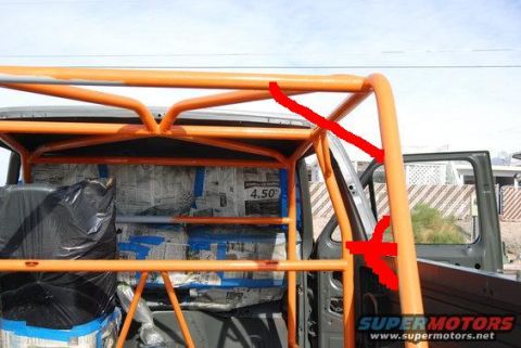 1981 Ford Bronco - Roll cage installation in progress, interior panels covered with newspaper for protection.