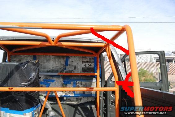 Orange roll cage being installed inside a vehicle, with newspaper covering the interior panels