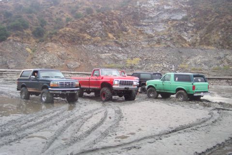 1995 Ford Bronco - Four-wheel-drive vehicles navigate a muddy terrain in Azusa Canyon.