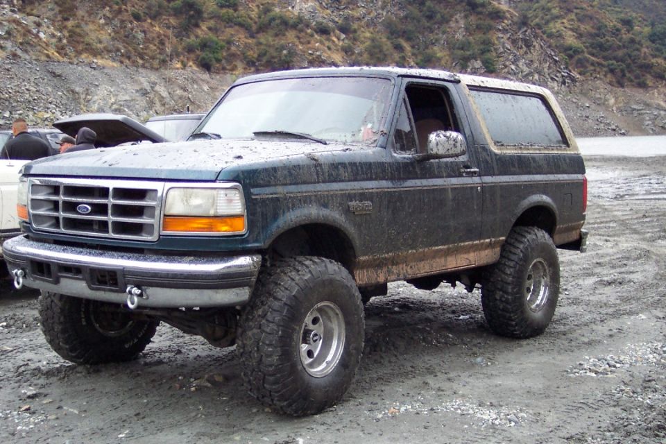 Dark green 1995 Ford Bronco with lifted suspension and large tires