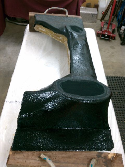 1975 Ford Bronco - A black intake manifold is shown resting on wooden blocks, likely for restoration or modification.