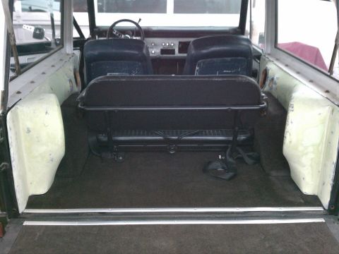 1975 Ford Bronco - The interior of a classic Ford Bronco is shown from the rear, looking forward towards the dashboard.