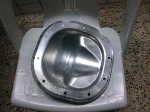 1998 Ford Crown Victoria - An aluminum differential cover is shown resting on a white plastic chair, with a watermark at the bottom right.
