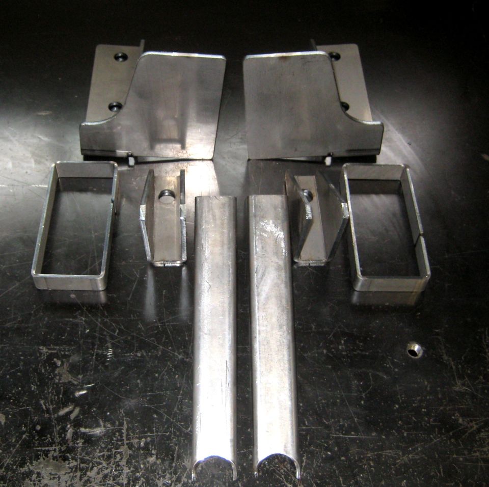 Metal brackets and tubes arranged on a dark surface