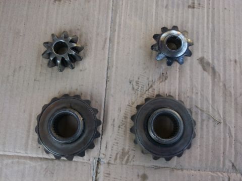 1998 Ford Crown Victoria - A set of four gears, likely for a vehicle's differential, are displayed on a wooden surface.