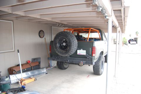 1982 Ford Bronco - This 1982 Ford Bronco is equipped with a roll cage and a rear-mounted spare tire, parked in a covered area.