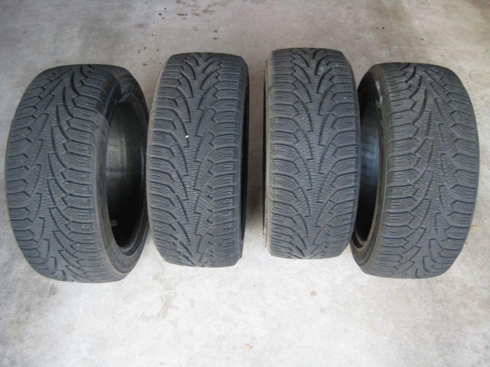 Four winter tires on a concrete surface