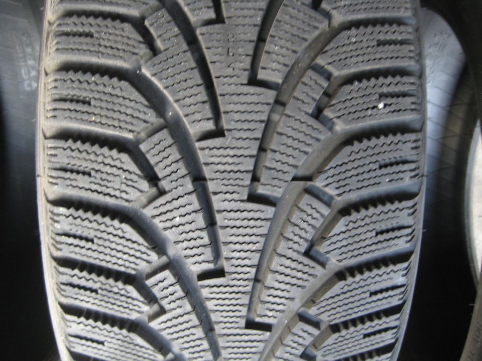 Close-up of a tire tread with deep grooves and sipes