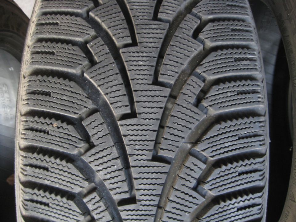 Close-up of a black tire tread with a complex pattern of sipes and blocks