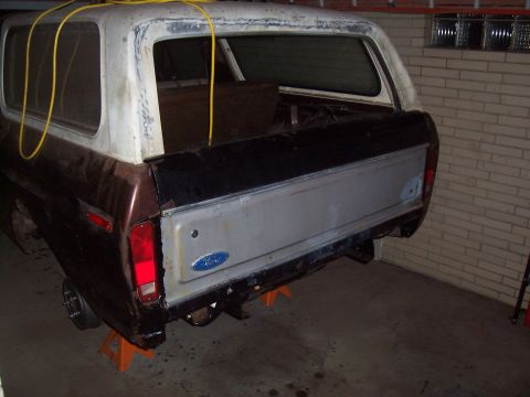 1979 Ford Bronco - The rear of a two-tone Ford Bronco is shown with its tailgate open.