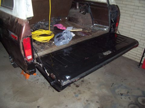 1979 Ford Bronco - A close-up view of a black car hood, showing its reflective surface and subtle contours.