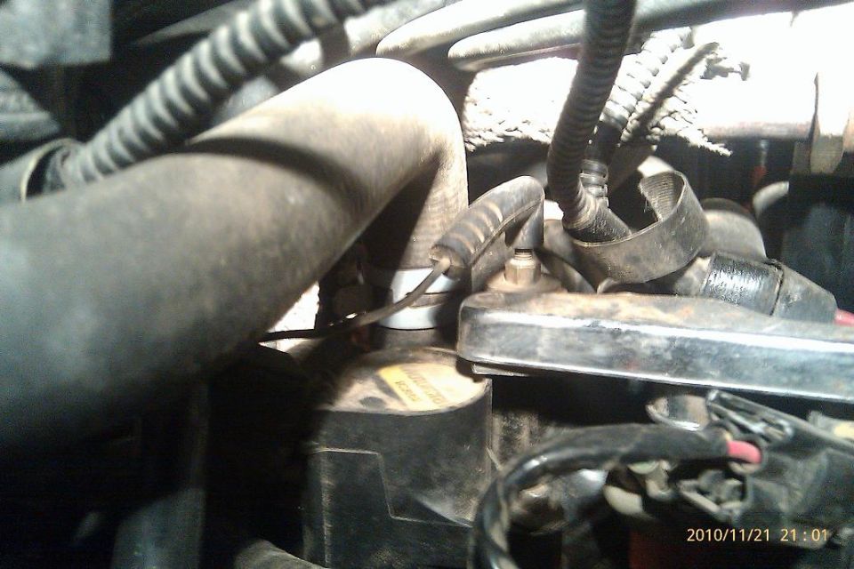 Engine part with yellow label and hoses
