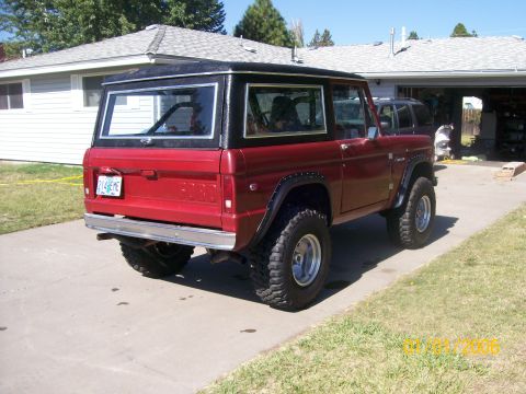 1970 Ford Bronco - Rear 3/4 view of a red 1970 Ford Bronco with a black hardtop.
