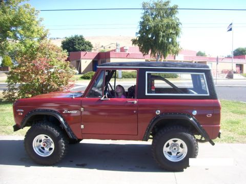 1970 Ford Bronco - A classic red Ford Bronco is parked outside a building on a sunny day.