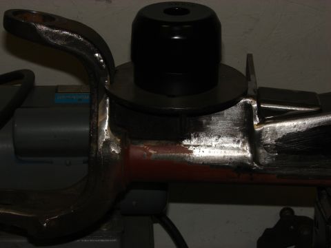 1993 Jeep Wrangler - A metal suspension part with a black bushing is shown mounted on a machine.