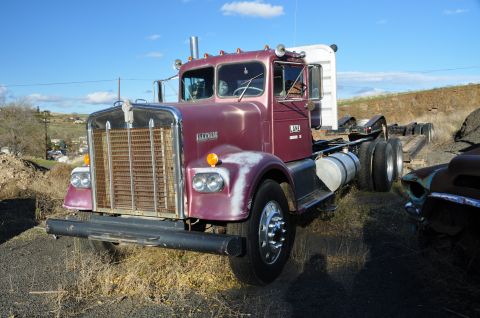 1959 Kenworth W900A - A maroon 1959 Kenworth W900A truck is seen parked outdoors with another vehicle partially visible to the right.