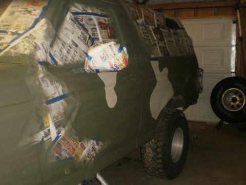 1995 Ford Bronco - A 1995 Ford Bronco is being prepped for camouflage paint, with windows and trim covered in newspaper.