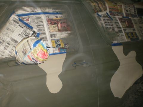 1995 Ford Bronco - The windows of a vehicle are covered with newspaper, indicating preparation for a paint job.