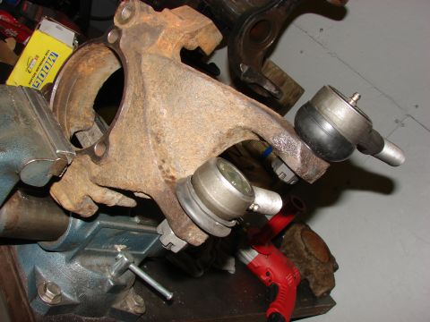 1993 Jeep Wrangler - Close-up of rusted suspension components, likely ball joints and a spindle, secured in a vise for repair or inspection.
